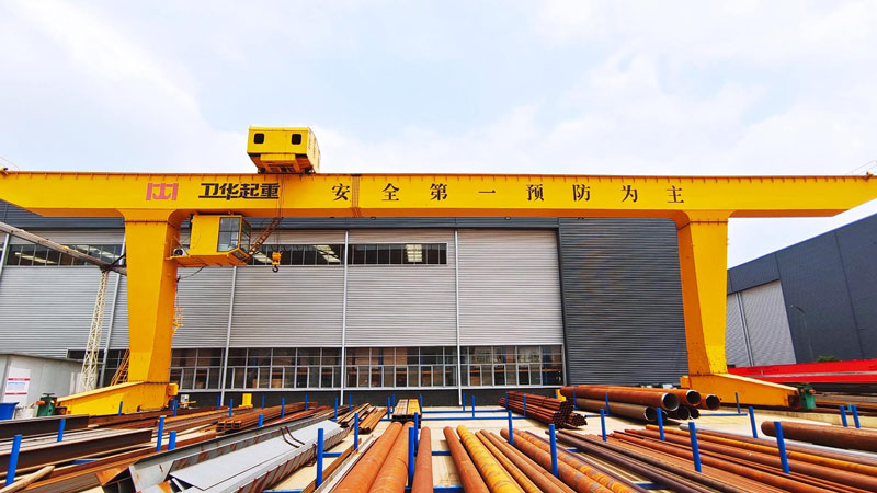 gantry crane equipped with a spreader beam for steel pipe handling