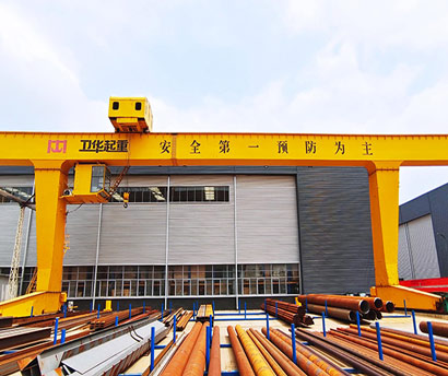 gantry crane equipped with a spreader beam for steel pipe handling